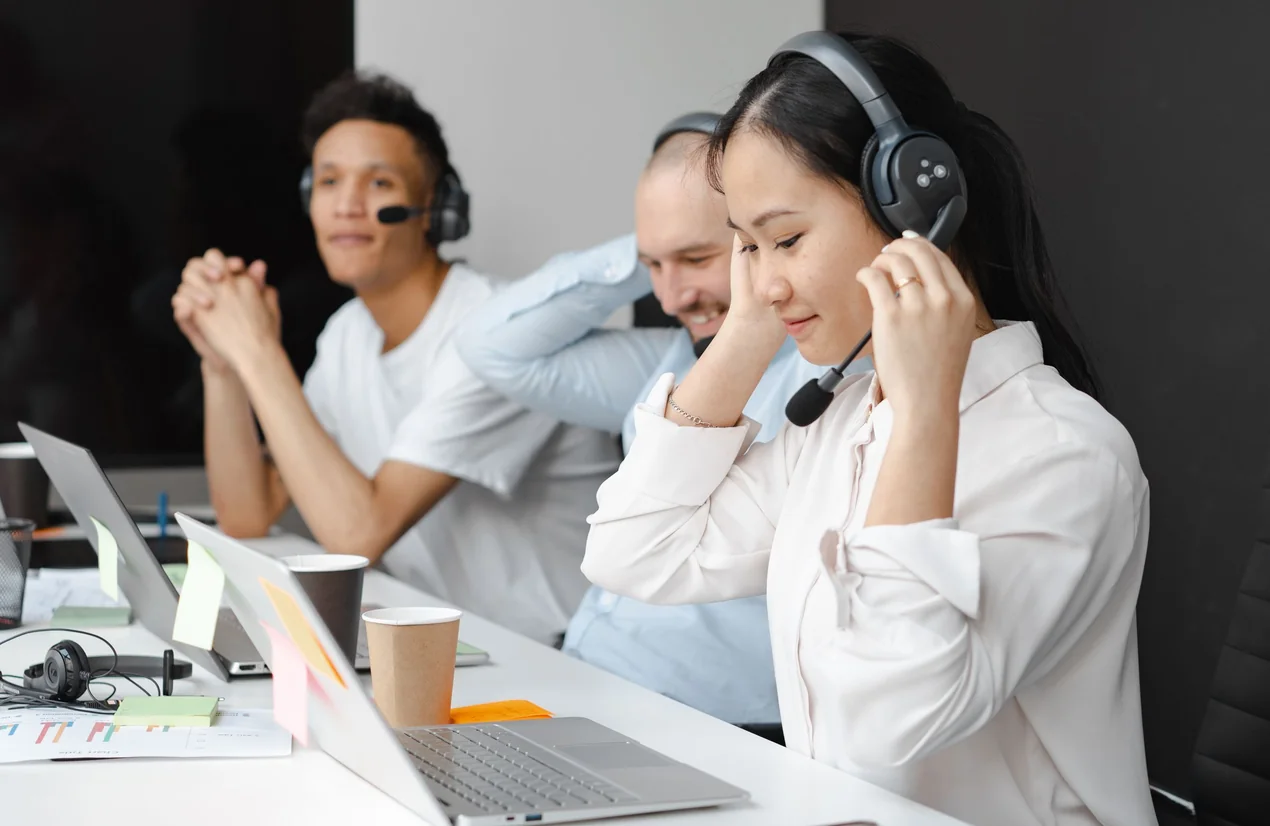 Un equipo comercial con cascos atendiendo llamadas desde sus portátiles