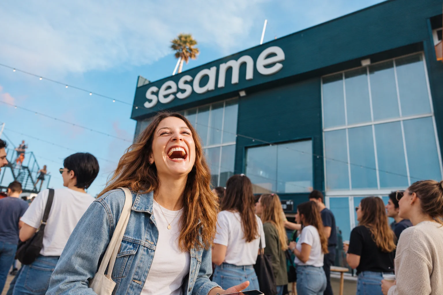 Una compañera de Sesame riéndose junto al equipo delante de la oficina